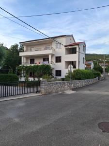 a large white house with a stone wall next to a street at Adriatic Pearl Povile in Povile