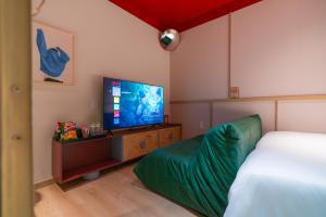 a bedroom with a bed and a flat screen tv at Benri Hotel Signature in Ho Chi Minh City