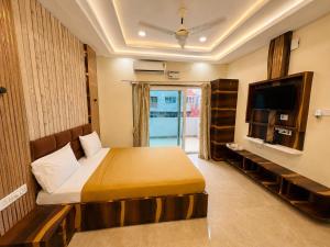 a hotel room with a bed and a television at Annapurna Prestine Puri - Comfortable Stay Near Jagannath Temple - with Free Wi-fi, Parking, Restaurant in Puri