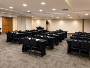 a room with chairs and tables and a stage at Slaviero Hotel Porto Alegre Moinhos in Porto Alegre