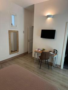 a room with a table and a television on the wall at Domus Alberta in Lecce