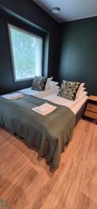 a large bed in a room with a window at Hotelli Pato in Nakkila +4 photos