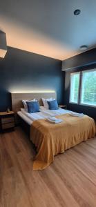 a bedroom with a large bed with blue pillows at Hotelli Pato in Nakkila