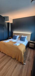 a bedroom with a large bed with blue walls at Hotelli Pato in Nakkila