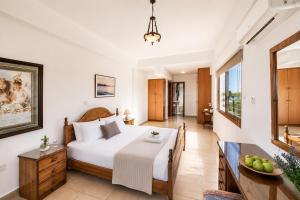 a bedroom with a large white bed and a table at Villa Argaka Heights in Argaka +25 photos