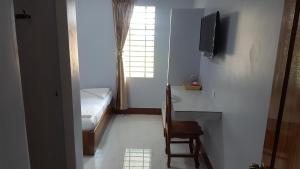 a room with a bed and a desk and a television at KampongBay Makeng II Guesthouse in Kampot