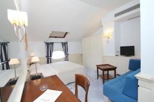 a room with a bed and a table and a blue couch at Residenza D'epoca La Corallina in Castellabate