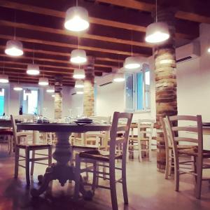 a dining room with a table and chairs and lights at Agriturismo Casacarella in Cesena