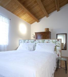 a bedroom with a white bed with white pillows at Agriturismo Casacarella in Cesena