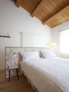 a white bedroom with a large bed with a chair at Agriturismo Casacarella in Cesena +6 photos