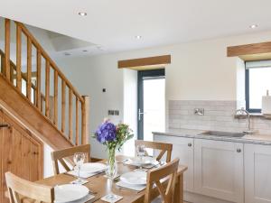 a dining room with a table and a kitchen at Deer Park Barn - Uk33323 in Reeth