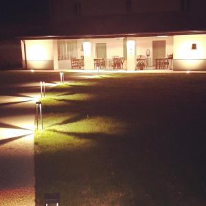 a building lit up at night with a reflection in a puddle at Agriturismo Casacarella in Cesena