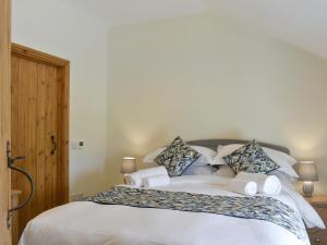 a bedroom with a large bed with white sheets and pillows at Deer Park Barn - Uk33323 in Reeth