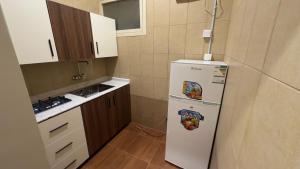 a small kitchen with a refrigerator with magnets on it at شقق jm احد رفيدة 2 in Ahad Rafidah