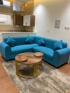a living room with a blue couch and a table at شقق jm احد رفيدة 2 in Ahad Rafidah
