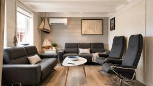 a living room with two couches and a table at Sjøhuset Sjøholt in Sjøholt