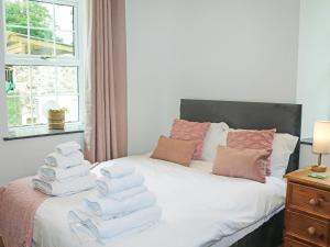 a pile of towels stacked on top of a bed at Gate House in Llangefni