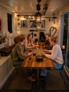 a group of people sitting around a wooden table at Sjøhuset Sjøholt in Sjøholt +9 photos