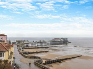 a view of a beach with a pier at Melrose Cottage in Cromer