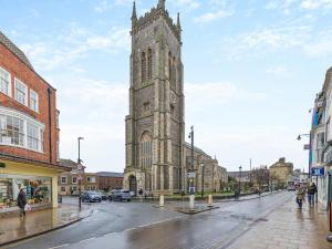 an old church with a tall tower on a street at Melrose Cottage in Cromer