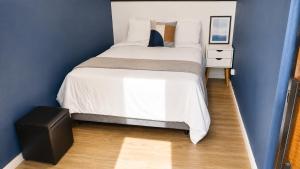 a bedroom with a large white bed and a blue wall at Studiohaus Pertence in São Paulo