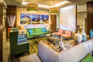 a living room with a green couch and chairs at Holiday Inn Express & Suites Salt Lake City South-Murray by IHG in Murray