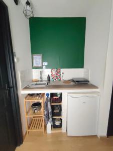 a small kitchen with a sink and a greenboard at Chambre 1 in Aniche