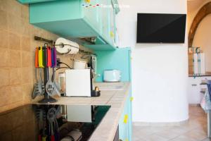 a kitchen with a blue counter top with a tv at Sky & Sea, Terre Marine in Volastra +11 photos