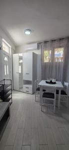 a living room with a table and a kitchen at Taksim Apartman in Igalo +12 photos