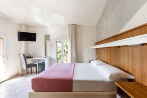 ein Schlafzimmer mit einem Bett und einem Schreibtisch mit Computer in der Unterkunft Hotel EMI in Calderara di Reno