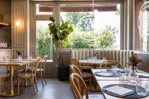 ein Restaurant mit Tischen und Stühlen und einem Fenster in der Unterkunft Hotel EMI in Calderara di Reno