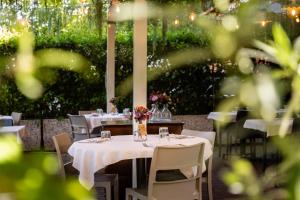 ein Tisch mit weißen Tischdecken und Blumen darauf in der Unterkunft Hotel EMI in Calderara di Reno + 45 Fotos
