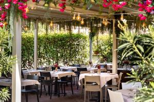 ein Restaurant mit Tischen, Stühlen und Blumen in der Unterkunft Hotel EMI in Calderara di Reno