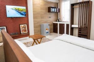 a room with a bed and a television on a wall at NioneEdge-Arusha-Moshono in Themi