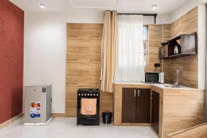 a small kitchen with a refrigerator and a sink at NioneEdge-Arusha-Moshono in Themi