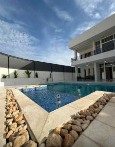 a swimming pool in front of a house at Diva Chalet in Sowayma