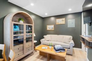 a living room with a couch and a table at Pelican Cliff Cottage - Tiny Home at Hampton Beach in Hampton