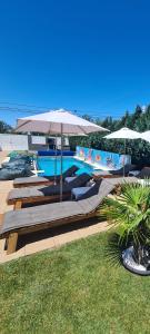 a swimming pool with umbrellas and lounge chairs next to a pool at Danube Home in Ostrovu Corbului