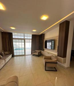 a large living room with a tv and a couch at Diva Chalet in Sowayma