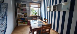 a dining room with a table and chairs and bookshelves at Willa Aura in Łeba