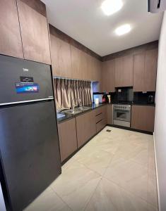 a kitchen with wooden cabinets and a refrigerator at Diva Chalet in Sowayma