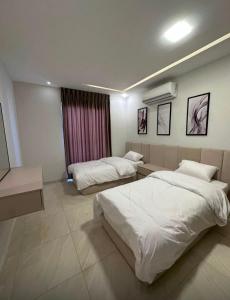 a hotel room with two beds and a couch at Diva Chalet in Sowayma +22 photos