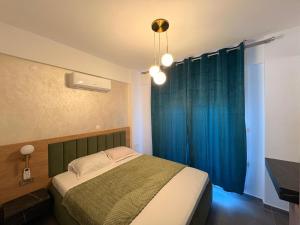 a bedroom with a bed and a blue curtain at Viasol Suites Thassos in Skala Rachoniou +56 photos