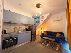 a kitchen and a living room with a blue couch at Viasol Suites Thassos in Skala Rachoniou