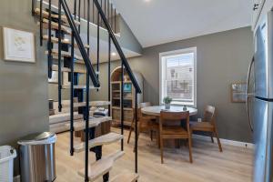 a dining room with a table and a spiral staircase at Sandy Toes Cottage - Tiny Home at Hampton Beach in Hampton