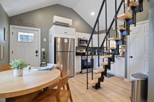 a kitchen and dining room with a table and stairs at Sandy Toes Cottage - Tiny Home at Hampton Beach in Hampton