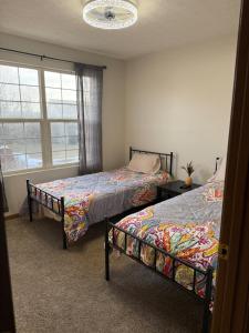 ein Schlafzimmer mit zwei Betten und einem Fenster in der Unterkunft The Wright Stay in Dayton