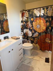 ein Badezimmer mit Toilette und einem Duschvorhang mit Blumenmuster in der Unterkunft The Wright Stay in Dayton
