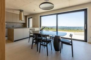 a kitchen with a table and chairs and a large window at Persolis luxury sun residence in Kojsko