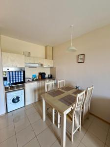 a kitchen with a table and chairs in a kitchen at Apartment Amelia in Rogachevo